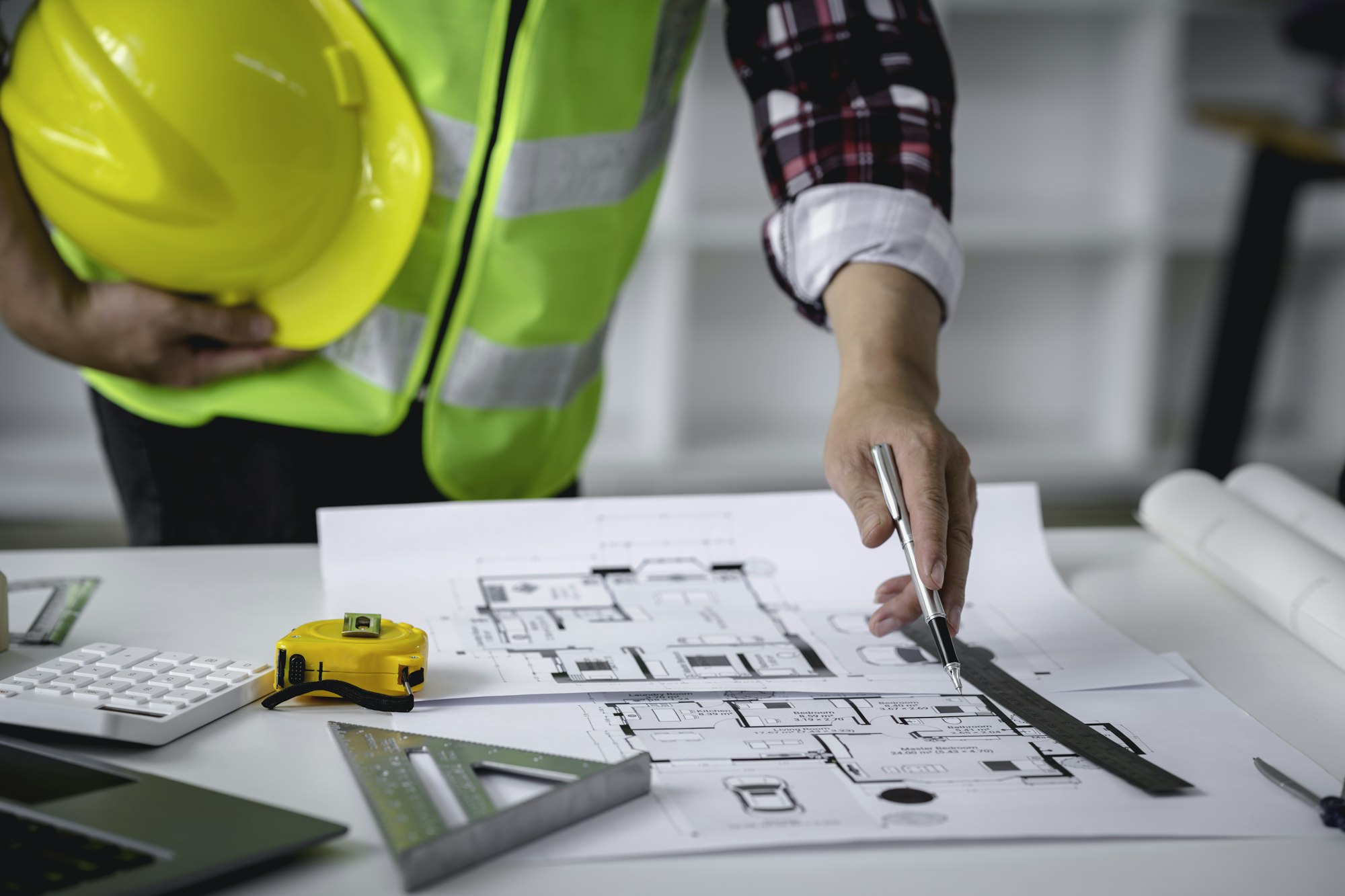 Concept architect, engineer, holding a pen pointing to a document showing the architect's structural