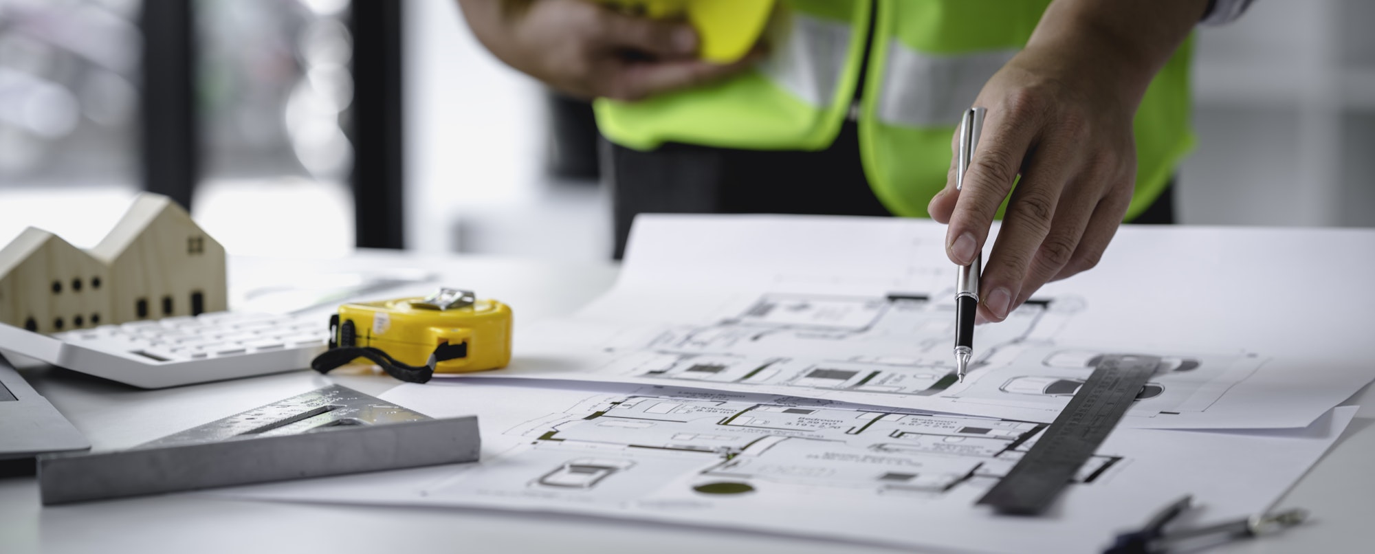 Concept architect, engineer, holding a pen pointing to a document showing the architect's structural