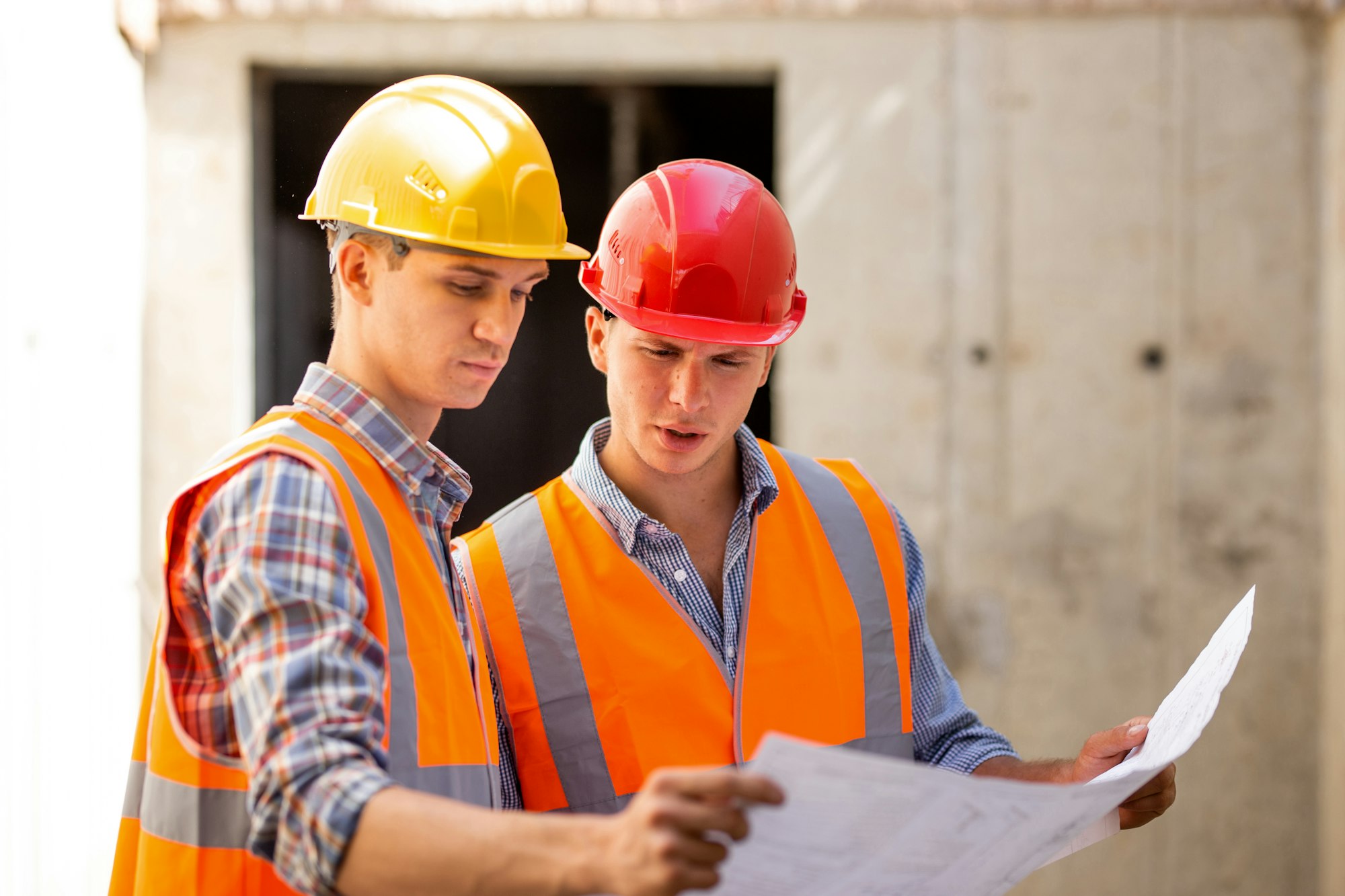 Structural engineer and construction manager dressed in work clothes and hard bats explore